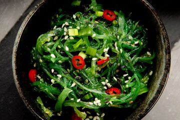 Wall Mural - Wakame seaweed with sesame and chilli on gray background. Asian food concept.