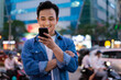 © Timeimage - Young Asian man using smartphone on the street at night