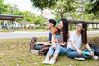 © sorapop - Happy young Asian young group of man and woman students are sitting during reading books in the park at university with copy space, Education back to university concept