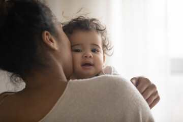 Wall Mural - close up portrait of young african american mother hold in arms hug cuddle little ethnic baby girl c