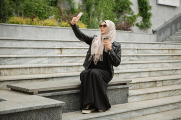 Wall Mural - modern stylish muslim woman in hijab in city street