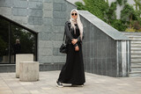 Fototapeta Młodzieżowe - modern stylish muslim woman in hijab in city street