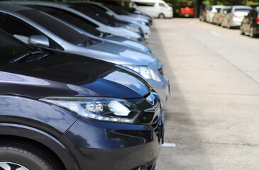 Wall Mural - Closeup of front side of dark blue car with  other cars parking in parking area.