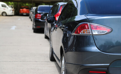 Wall Mural - Closeup of back, rear side of dark blue sedan car and other cars parking in outdoor parking area.