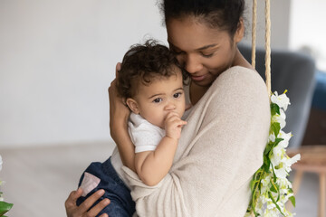 Wall Mural - happy caring young african american mother hold cuddle caress small ethnic baby daughter child. smil