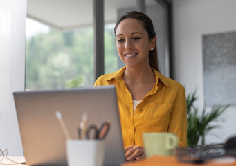 Wall Mural - Smiling woman working from home