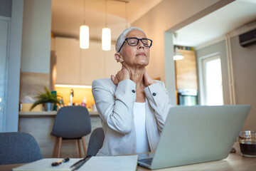 cropped shot of a mature businesswoman looking stressed out while working in her office at home. mat