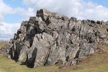 A Natural Large Rock Outcrop On A Countryside Hillside.
