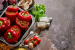 © Dash - Red bell stuffed paprika peppers in iron cooking pot with various ingredients on side