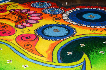  Rangoli, an art of arranging patterns with colorful rice grains, sand and flour with flower petals into geometrical shapes during dewali festival. Abstract Festive Background. Colorful arrangement wit