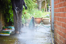 Cleaning Patio Paving With A High Pressure Washer The Man Is Using The Water To Clean The Garden Path