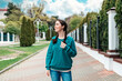 A young smiling girl student with pigtails standing on the street, at the entrance to the university. Outdoor. The concept of admission of students to the university