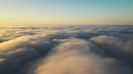 Wall Mural - striking aerial view of the sunset sky with the clouds below us. the shadows projected from the sun 