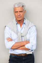 Wall Mural - Front of handsome older man with arms crossed by white wall