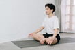 © Gengwit - Asian young man doing yoga at home
