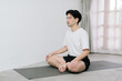 © Gengwit - Asian young man doing yoga at home
