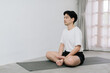 © Gengwit - Asian young man doing yoga at home