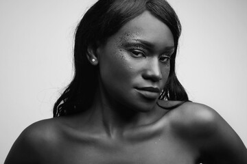 Wall Mural - Black woman posing in the studio, glittery make-up. Black and white portrait,