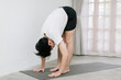 © Gengwit - Asian young man doing yoga at home