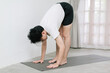 © Gengwit - Asian young man doing yoga at home