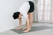 © Gengwit - Asian young man doing yoga at home