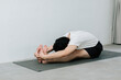 © Gengwit - Asian young man doing yoga at home
