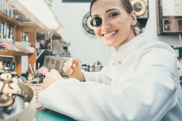 Wall Mural - Watchmaker woman looking at camera in her workshop