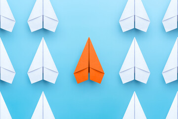 Wall Mural - Business concept for new ideas creativity and innovative solution, Group of white paper plane in one direction and one orange paper plane pointing in different way