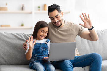 Wall Mural - Family having video call using laptop waving hands