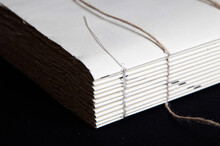 The Process Of Book Binding; Close Up Of A Raw Book After Sewing On Cords. Black Background