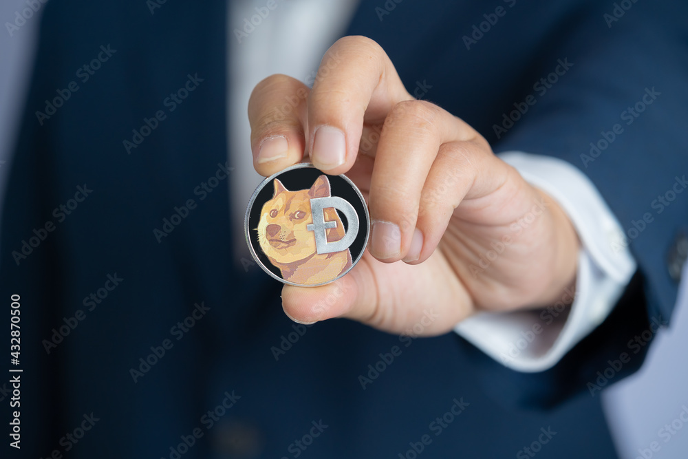 Dogecoin DOGE included with Cryptocurrency on hand business man wearing a blue suit. Filed and put and give to me.