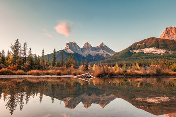 Wall Mural - Three sisters mountains of rocky mountains reflection on bow river in the morning at Canmore, Banff national park