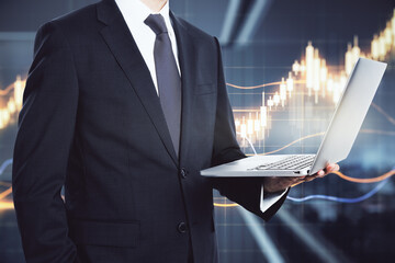 Poster - Businessman in a suit holding a laptop with a rising chart in the background closeup. Stock market analysis concept