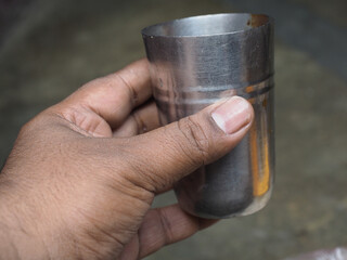 Wall Mural - A man holding a steel glass in old background