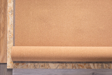 Poster - Cork roll and laminate floor on wood osb background texture. Cork background at wooden laminate floor