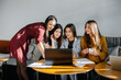 © Andrii - A group of young girls sit in an office and work at computers. Communication and training online.