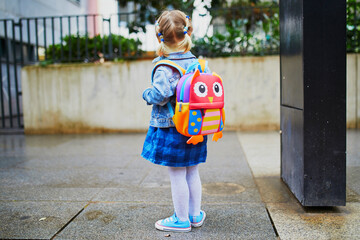 Wall Mural - Adorable toddler girl with funny backpack ready to go to daycare, kindergarten or school