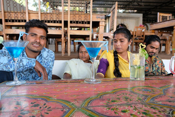 Sticker - Group of Indian male and female with glasses of different cocktails on the table