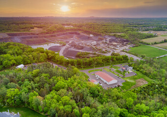 Aerial view of opencast mining quarry with lots of machinery at work in middle of forest on Pennsylvania, USA