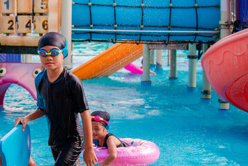 Wall Mural - Children frolic at the water park. It is a sunny, perfect day for getting wet and playing hard