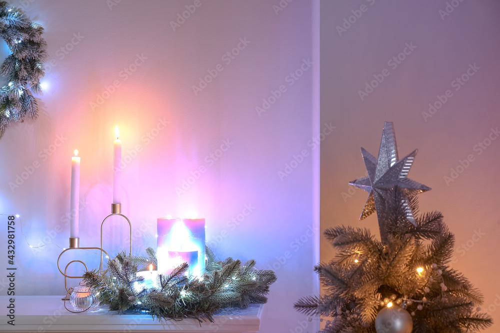 Candles and wreath on mantelpiece decorated for Christmas