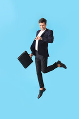 Poster - Jumping man with briefcase and wristwatch on color background