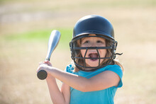 Funny Kid Up To Bat At A Baseball Game. Close Up Portrait.
