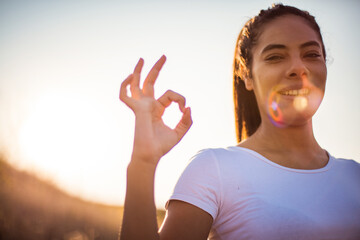 Young woman standing outside on a sunny day. Focus is on hand.  Perfect day.