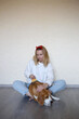 © Aleksandra Iarosh - a young woman combing a beagle dog with a furminator. grooming at home