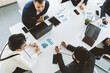 © xartproduction - top view Group of young business people working and communicating while sitting at the office desk together with colleagues sitting. business meeting