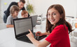 © kegfire - Smiling girl browsing laptop during programming lesson