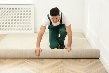 Sticker - Worker rolling out new carpet in room