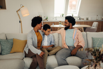 Wall Mural - Afro family sitting on sofa in the living room and socializing