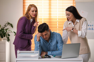 Wall Mural - Coworkers bullying their colleague at workplace in office